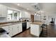 A bright kitchen featuring granite countertops, white cabinets, and a breakfast bar with pendant lighting at 1444 Trail Creek Ct, Carmel, IN 46032