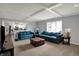 Open-concept living room featuring blue sofas, a kitchen view, and a modern entertainment setup at 1444 Trail Creek Ct, Carmel, IN 46032