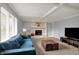 A comfortable living room featuring a brick fireplace, built-in shelves, a blue sofa, and soft lighting at 1444 Trail Creek Ct, Carmel, IN 46032