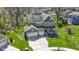 Expansive green lawn complements this two-story home with an attached three-car garage and mature trees at 15385 Ellington Dr, Fishers, IN 46040