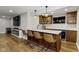 Finished basement showcasing a wet bar with a marble countertop, wooden cabinets, four bar stools, and fireplace at 15385 Ellington Dr, Fishers, IN 46040