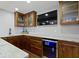 Basement bar area with cabinets, sink, cooler, marble countertop, and television mounted on the wall at 15385 Ellington Dr, Fishers, IN 46040