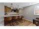 Finished basement showcasing a wet bar with a marble countertop, wooden cabinets, and four bar stools at 15385 Ellington Dr, Fishers, IN 46040