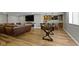 A finished basement with a bar, fireplace, foosball table, hardwood floors, and a brown leather couch at 15385 Ellington Dr, Fishers, IN 46040