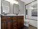 Bathroom showcasing a double vanity with granite counters and tiled bathtub with a glass door at 15385 Ellington Dr, Fishers, IN 46040