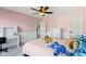 A lovely pink bedroom with a ceiling fan and a desk with ample lighting at 15385 Ellington Dr, Fishers, IN 46040