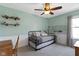 A well-lit bedroom with a trundle bed, light green walls, and a ceiling fan at 15385 Ellington Dr, Fishers, IN 46040
