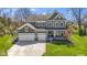 A charming two-story home with a three-car garage, inviting front porch, and manicured lawn and landscape at 15385 Ellington Dr, Fishers, IN 46040