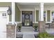 Inviting front porch with decorative columns, charming wreath, and well-manicured landscaping at 15385 Ellington Dr, Fishers, IN 46040
