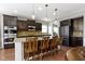 A spacious kitchen featuring a large island with seating, sleek black appliances, and stylish pendant lights at 15385 Ellington Dr, Fishers, IN 46040