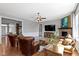 Cozy living room with warm leather seating, stone fireplace, and wood accents, creating an inviting space at 15385 Ellington Dr, Fishers, IN 46040