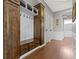 Practical mud room with custom wood cabinets, bench, and hooks for organization at 15385 Ellington Dr, Fishers, IN 46040