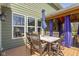 Inviting outdoor dining area with wood-look flooring and ample seating under a large umbrella at 15385 Ellington Dr, Fishers, IN 46040