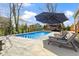 Relaxing backyard retreat featuring a pristine pool, sun loungers, and a shaded seating area at 15385 Ellington Dr, Fishers, IN 46040