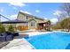 Scenic backyard view of sparkling in-ground pool, patio with lounge chairs, and covered seating at 15385 Ellington Dr, Fishers, IN 46040