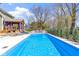 Backyard view of a refreshing in-ground pool with patio seating, landscaping, and wooden pergola at 15385 Ellington Dr, Fishers, IN 46040