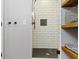 Stylish shower with white subway tile, hexagon tile floor, and built-in storage nook at 15385 Ellington Dr, Fishers, IN 46040