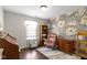 Inviting bedroom boasts a decorative wallpaper, a comfortable armchair, and a wooden bookcase at 15501 Landsbrook E Run, Noblesville, IN 46060