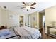 This bedroom has a ceiling fan, blue floral wall art, hard wood floors, and leads to the bathroom at 15501 Landsbrook E Run, Noblesville, IN 46060