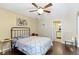 This bedroom has a ceiling fan, blue floral wall art, and hard wood floors at 15501 Landsbrook E Run, Noblesville, IN 46060