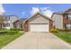 Inviting front exterior featuring a two-car garage, brick accents, well-maintained lawn, and clear driveway at 15501 Landsbrook E Run, Noblesville, IN 46060