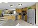Open kitchen area with stainless steel appliances, wooden cabinets, and view of the living area at 15501 Landsbrook E Run, Noblesville, IN 46060