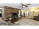 Stylish living room featuring a wood accent wall, ceiling fan, and hardwood floors at 15501 Landsbrook E Run, Noblesville, IN 46060