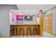 Finished basement bar with wood cabinets, grey walls, four barstools, and a television at 1583 E Osprey Dr, Greenfield, IN 46140