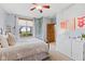 Bright bedroom featuring a decorative ceiling fan and large window overlooking the front yard at 1583 E Osprey Dr, Greenfield, IN 46140