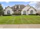 Stunning white brick home with manicured lawn, arched windows and dormers offering timeless appeal at 1583 E Osprey Dr, Greenfield, IN 46140