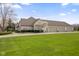 Side view of a white brick home showcasing a spacious three-car garage and circular driveway at 1583 E Osprey Dr, Greenfield, IN 46140