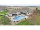 Aerial view of backyard with swimming pool, outdoor kitchen, hot tub, patio, and white brick home at 1583 E Osprey Dr, Greenfield, IN 46140