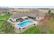 Aerial view of backyard with swimming pool, outdoor kitchen, hot tub, patio, and white brick home at 1583 E Osprey Dr, Greenfield, IN 46140