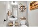 Stylish powder room with a pedestal sink, decorative shelves, and modern fixtures, perfect for guests at 1712 Rosette Way, Indianapolis, IN 46202