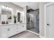 Modern bathroom with double vanities, a glass-enclosed shower, and sleek fixtures; blending style and functionality at 1712 Rosette Way, Indianapolis, IN 46202