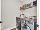 Functional laundry room with modern washer and dryer, storage shelves, and ample space at 1712 Rosette Way, Indianapolis, IN 46202