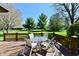 Backyard deck featuring a table and chairs offers a scenic view of the well-manicured lawn and lush trees at 1927 Pheasant Way, Greenwood, IN 46143