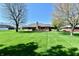 Expansive backyard with a lush green lawn, mature trees, and a brick home with a cozy deck at 1927 Pheasant Way, Greenwood, IN 46143