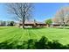 View of the lush backyard, featuring a well-manicured lawn and a brick home with a deck at 1927 Pheasant Way, Greenwood, IN 46143