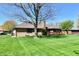 Expansive backyard with well-kept lawn, mature trees, and a charming brick home at 1927 Pheasant Way, Greenwood, IN 46143