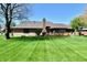 Expansive backyard with a well-maintained lawn, a brick chimney, and a wooden deck perfect for entertaining at 1927 Pheasant Way, Greenwood, IN 46143