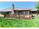 A well-maintained backyard featuring a wooden deck, brick home, and lush green lawn at 1927 Pheasant Way, Greenwood, IN 46143