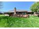 Lush green backyard featuring a brick home with a wooden deck, ideal for outdoor entertaining at 1927 Pheasant Way, Greenwood, IN 46143