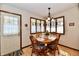 Cozy dining area with wood table and chairs, bright windows with lace curtains, and laminate floors at 1927 Pheasant Way, Greenwood, IN 46143