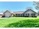 Charming brick home with an attached two-car garage and a well-manicured lawn, shrubs and a young tree at 1927 Pheasant Way, Greenwood, IN 46143
