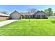 Charming brick home featuring a lush green lawn, manicured bushes, and an attached two car garage at 1927 Pheasant Way, Greenwood, IN 46143