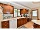 Cozy kitchen featuring wood cabinets, white countertops, white appliances, and a window overlooking the yard at 1927 Pheasant Way, Greenwood, IN 46143