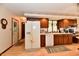 Spacious kitchen with wood cabinets, white appliances, and laminate flooring, door to outside at 1927 Pheasant Way, Greenwood, IN 46143