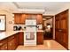 Kitchen with wood cabinets, white countertops and appliances, opening into another room at 1927 Pheasant Way, Greenwood, IN 46143
