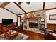 Inviting living room featuring a brick fireplace, hardwood floors, and exposed beam ceiling at 1927 Pheasant Way, Greenwood, IN 46143